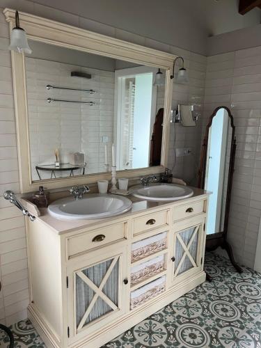 a bathroom with two sinks and a large mirror at Casa del Maestro, Seguencu in Següenco