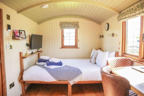 a small bedroom with a bed and a tv at Rose in Rhayader