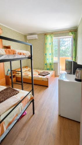 a room with three bunk beds and a kitchen at У Олексія in Karolino-Buhaz
