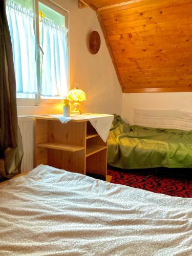 a bedroom with a bed and a desk and a window at Erdei weekend ház in Jögödfürdő