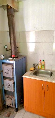 a kitchen with an old stove and a sink at Erdei weekend ház in Jögödfürdő