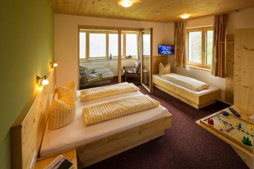 a room with two beds and a television in it at Jägerstüble in Damuls