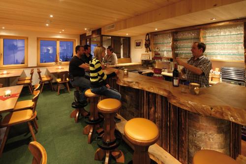 a group of people sitting at a bar in a restaurant at Jägerstüble in Damuls