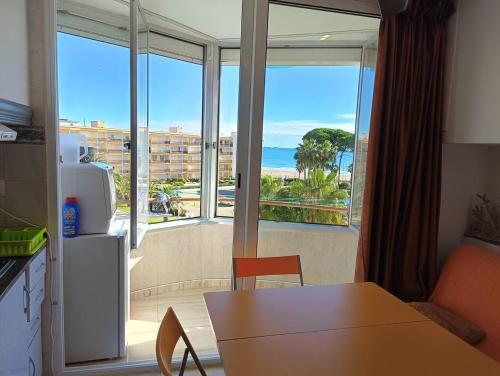 a kitchen with a table and a view of the ocean at Promar La Pineda Port Aventura in La Pineda