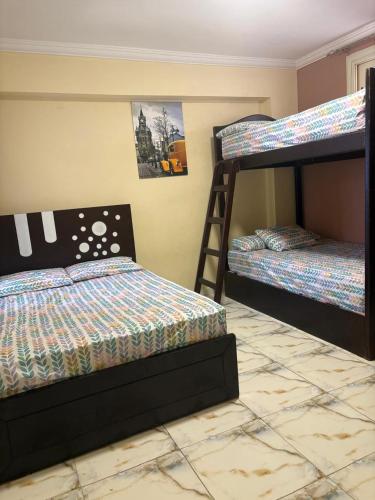 a bedroom with two bunk beds and a ladder at شالية ديمورا للعائلات in Dawwār Muḩammad Abū Shunaynah