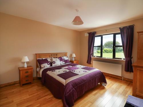 a bedroom with a large bed and a window at Strand House in Bannow