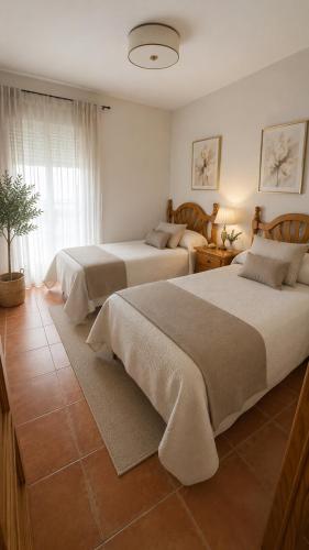 a bedroom with two beds and a window at Poseidón in Quesada