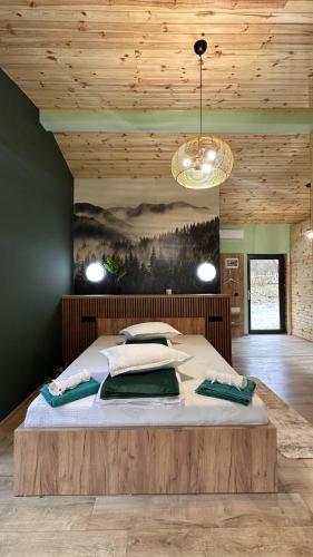 a large bed in a room with a wooden ceiling at Wolfmoon Riverside in Lupşa