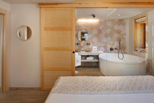 a bathroom with a bath tub and a sink at Hotel Boutique Mediodía & Apartments in Plan