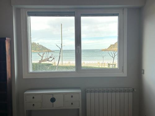 a window with a view of the beach at Samsara in San Sebastián