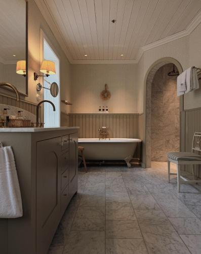 ein großes Badezimmer mit Badewanne und Waschbecken in der Unterkunft Hotel Union Øye in Øye