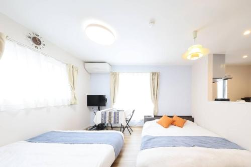 two beds in a room with white walls and windows at 天空山 in Kawagoe