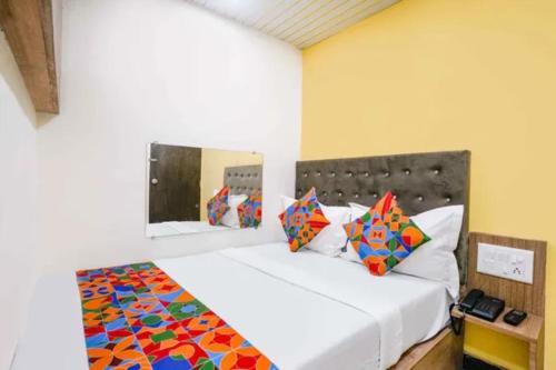 a bedroom with a large white bed with colorful pillows at Via Palace Residence in Mumbai