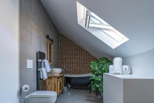 a bathroom with a sink and a bath tub at La Maison du Corsaire et Les Ateliers - deux adresses à Honfleur in Honfleur
