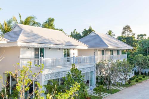 a large white house with a balcony at Moeimanee Resort in Mae Sot