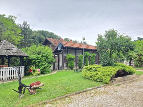 a house with a statue of a dog in the yard at Vila PAUN in Doboj