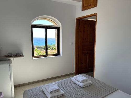 a white room with a bed with two towels on it at Aqua Marine in Falasarna
