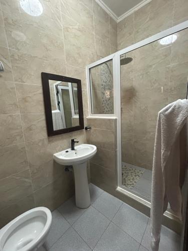 a bathroom with a toilet and a sink and a shower at Residencial Nyelete in Vilanculos