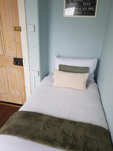 a white bed with a pillow on top of it at Glenlara House in Youghal