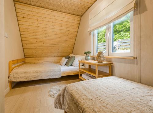 a room with two beds and a window at Domki nad Zaporą w centrum Soliny przy Zaporze - wybrane domki z jacuzzi in Solina