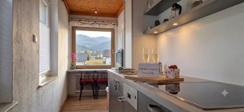 a kitchen with a counter and a large window at Boutique73 Sunset in Altossiach