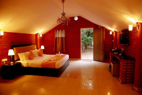 a bedroom with a bed and a red brick wall at Ananya Eco Resort in Surūrnagar