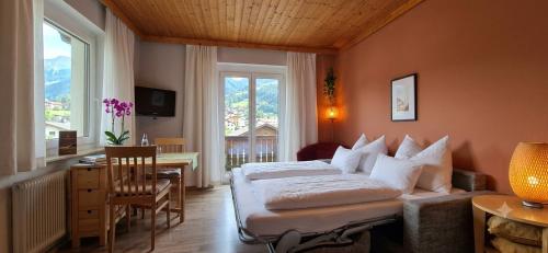a bedroom with a bed and a desk and a window at Boutique73 Sunset in Altossiach