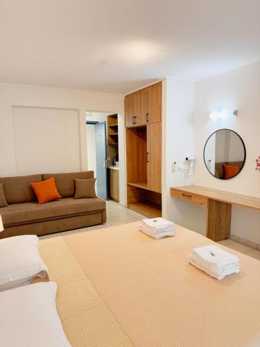 a living room with a couch and a mirror at Emporios Bay Hotel Chios in Emporeiós