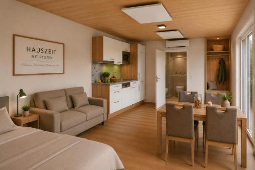 a bedroom with a bed and a table and a kitchen at Hauszeit mit Pfoten in Litschau