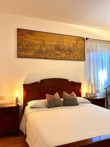 a bedroom with a bed with a painting on the wall at La Verde Dimora in Marano Vicentino