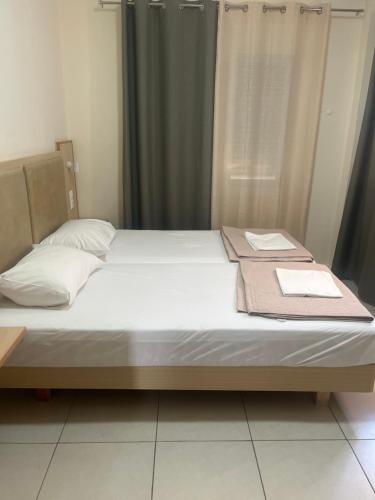 a bed with white sheets and a towel on it at Sweetmar guest Rooms-ground floor in Kos