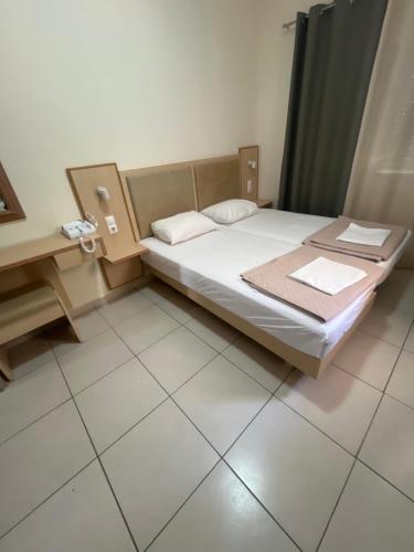 a small bedroom with a bed and a desk at Sweetmar guest Rooms-ground floor in Kos