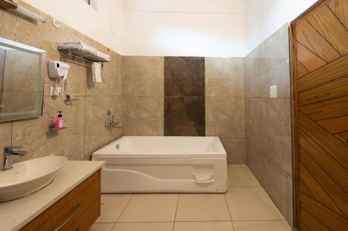 a bathroom with a tub and a toilet and a sink at Justa Natures Nest Resort in Bullāwāla