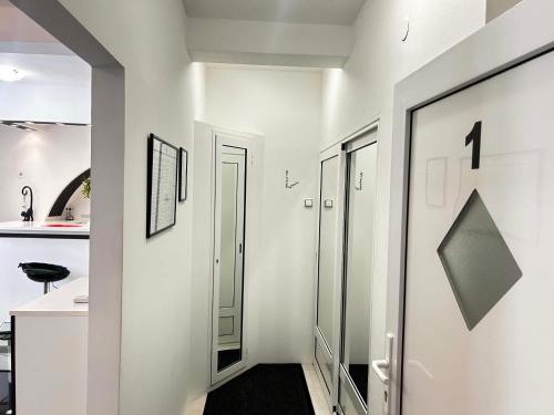a hallway with white walls and a glass door at Apartment Decumana in Krk