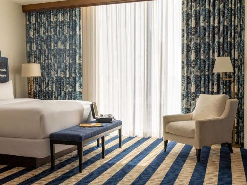 a hotel room with a bed and a chair at Fairmont Austin in Austin