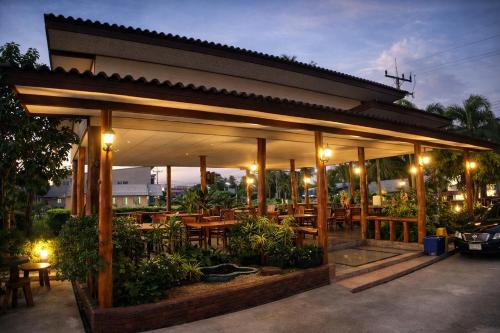 a restaurant with tables and chairs and lights at Lay de Bua Resort in Phatthalung