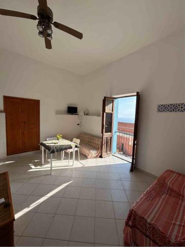 a living room with a table and a balcony at Melania Home in Filicudi