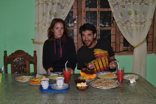 een man en een vrouw aan een tafel met eten bij Thilini homestay in Ella
