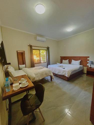 a hotel room with two beds and a table and a table sidx sidx at Residencial Nyelete in Vilanculos