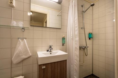 a bathroom with a sink and a shower at Bardufoss Hotell in Bardufoss