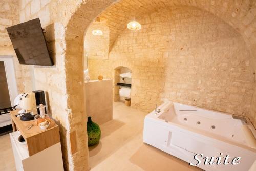 ein Badezimmer mit einer Badewanne in einer Steinwand in der Unterkunft Amber's House in Casamassima