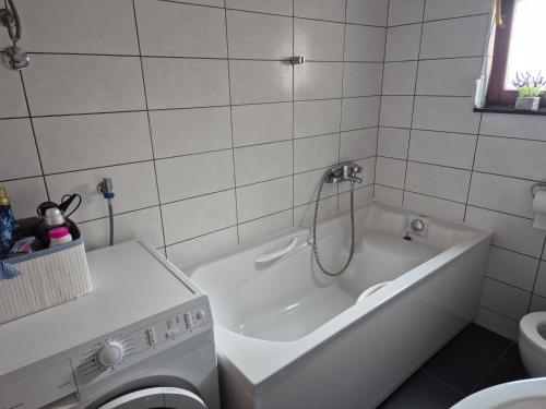 a bathroom with a tub and a washing machine at Apartman Pecara in Široki Brijeg