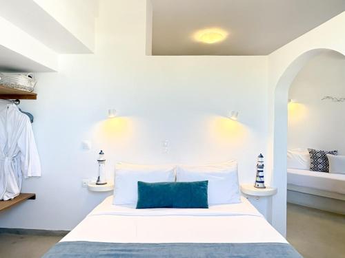 a white bedroom with a bed with a blue pillow at Villa Solasta #2 with jacuzzi in Santorini in Akrotiri