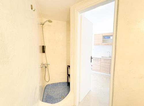 a bathroom with a shower with a blue rug at Villa Solasta #2 with jacuzzi in Santorini in Akrotiri