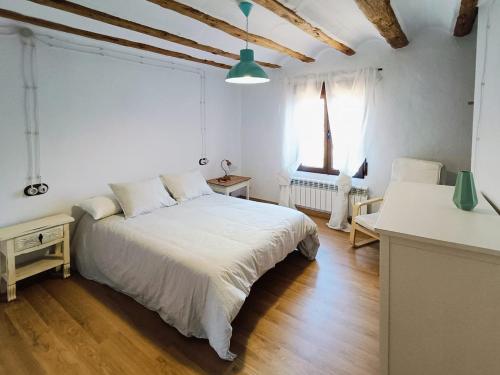 a bedroom with a large white bed and two windows at Casa Remedios in Cubla