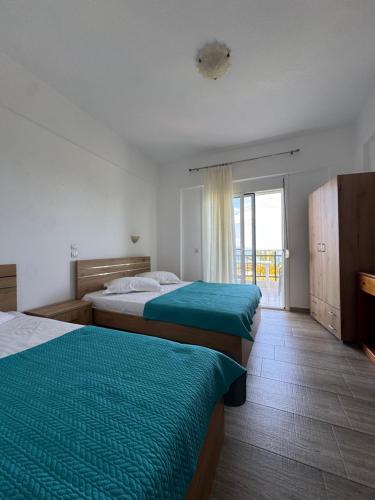 a hotel room with two beds and a window at Barbara House in Kriopigi