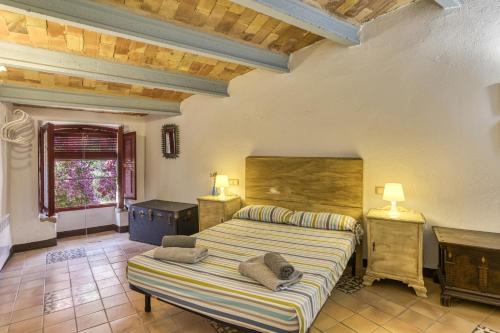a bedroom with a bed and a table and a window at Casa Blava in Orriols