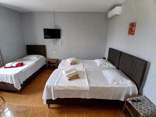 a bedroom with two beds and a flat screen tv at Nika Inn Kobuleti in Kobuleti