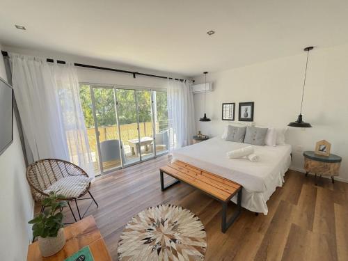 a bedroom with a bed and a table and a window at La Bonita Suites Punta Colorada in Punta Colorada