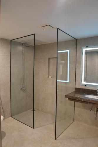 a glass shower in a bathroom with a sink at RT Serene Hotel - Hyderabad in Hyderabad